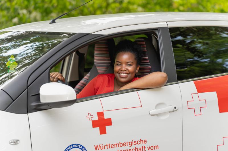 Eine Frau sitzt im Auto und schaut aus dem Fenster 